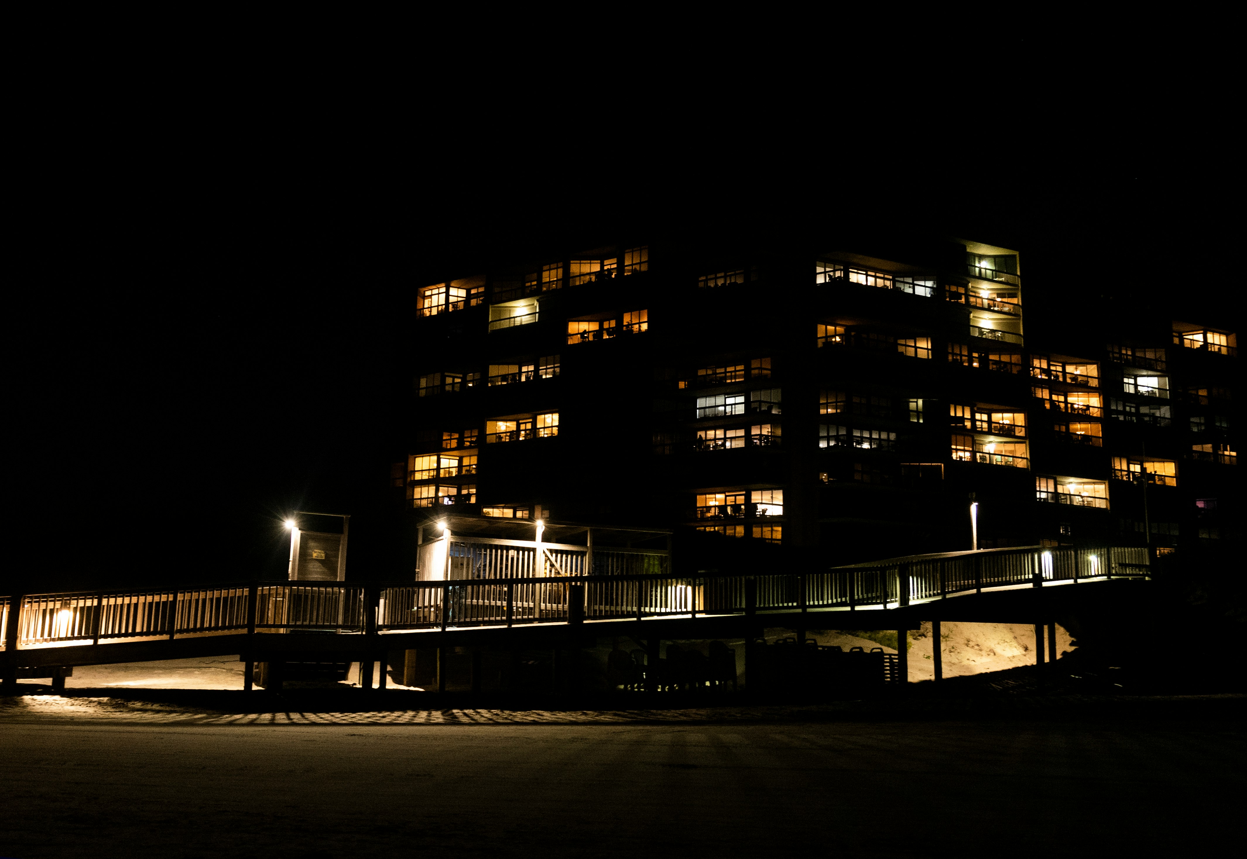 people walking on sidewalk near building during night time